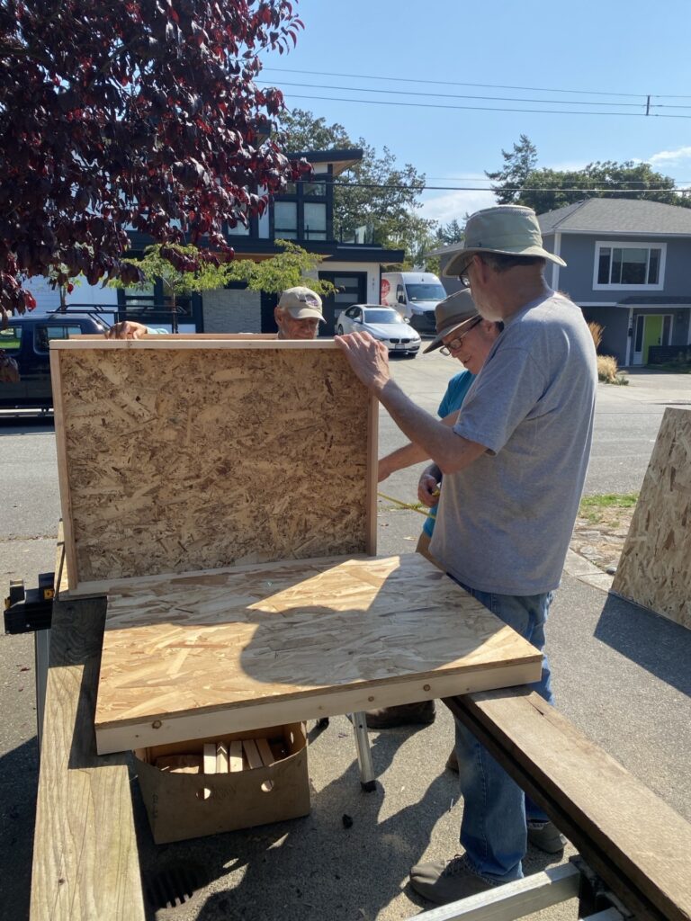 Esquimalt Men's Shed members participating in pantry building.
